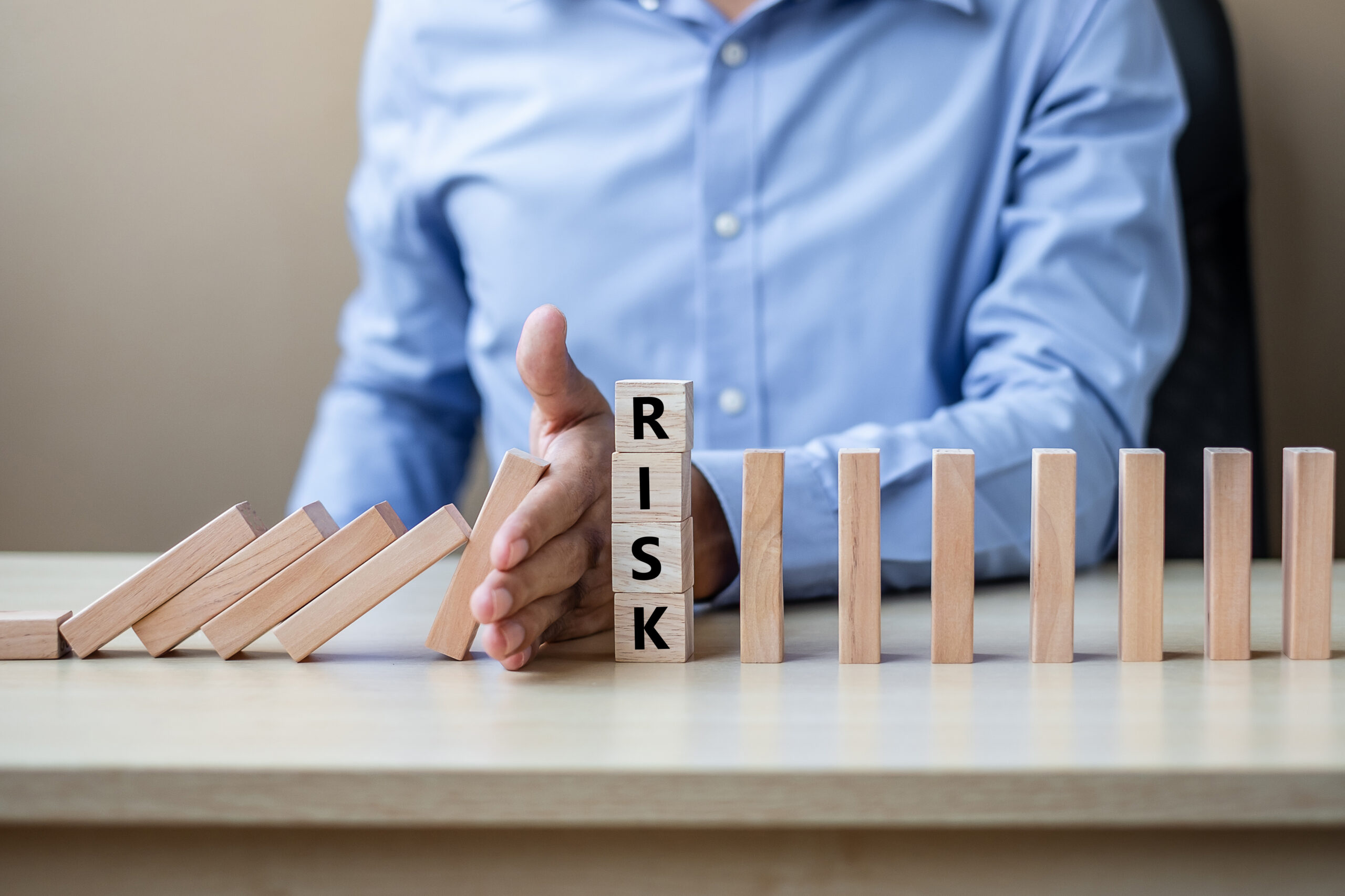 Businessman hand Stopping Falling wooden Blocks or Dominoes. Bus Businessman hand Stopping Falling wooden Blocks or Dominoes. Business, Risk Management, Solution, Insurance and strategy Concepts