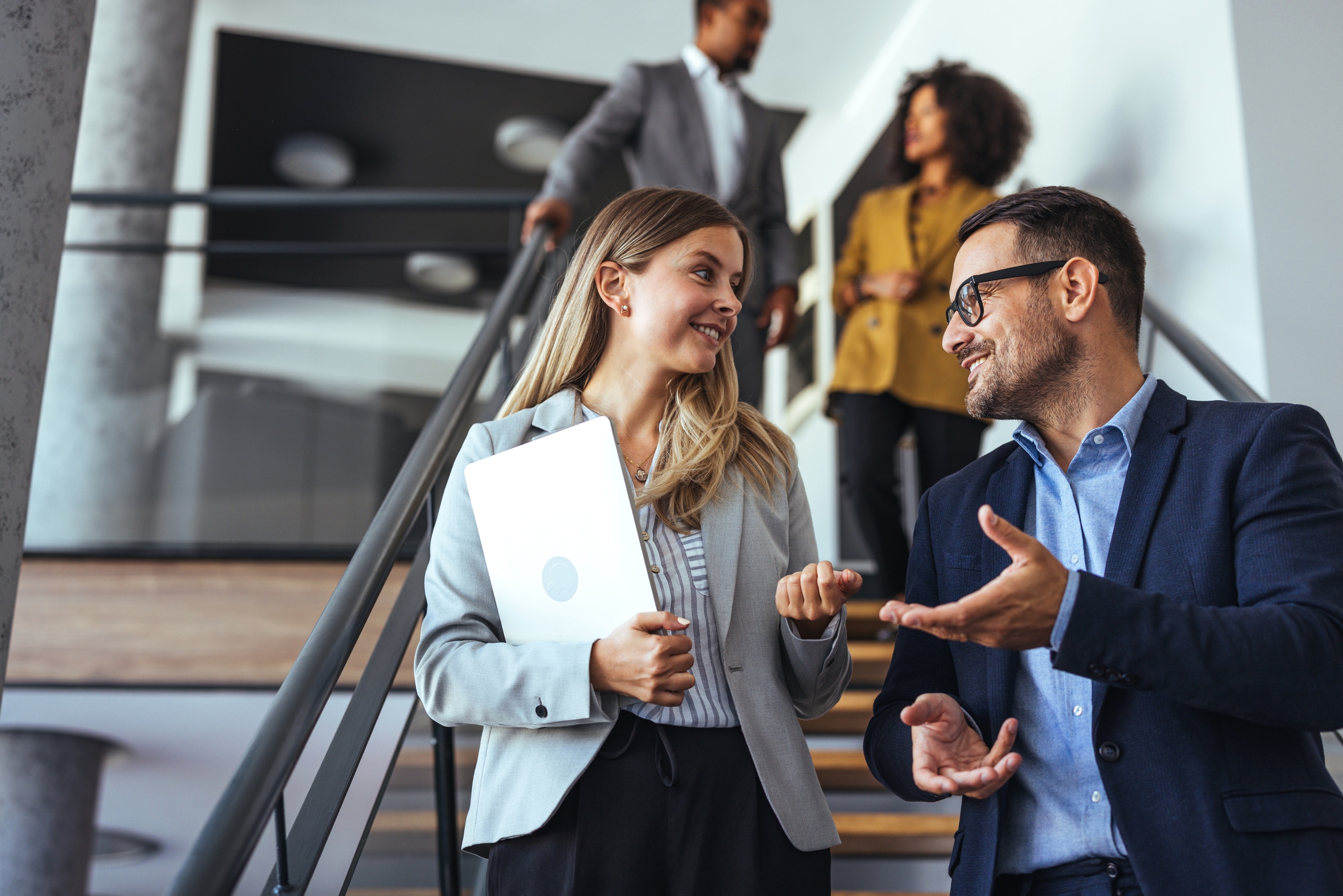 Colleagues Engaging in a Pleasant Discussion on Office Staircase Colleagues Engaging in a Pleasant Discussion on Office Staircase