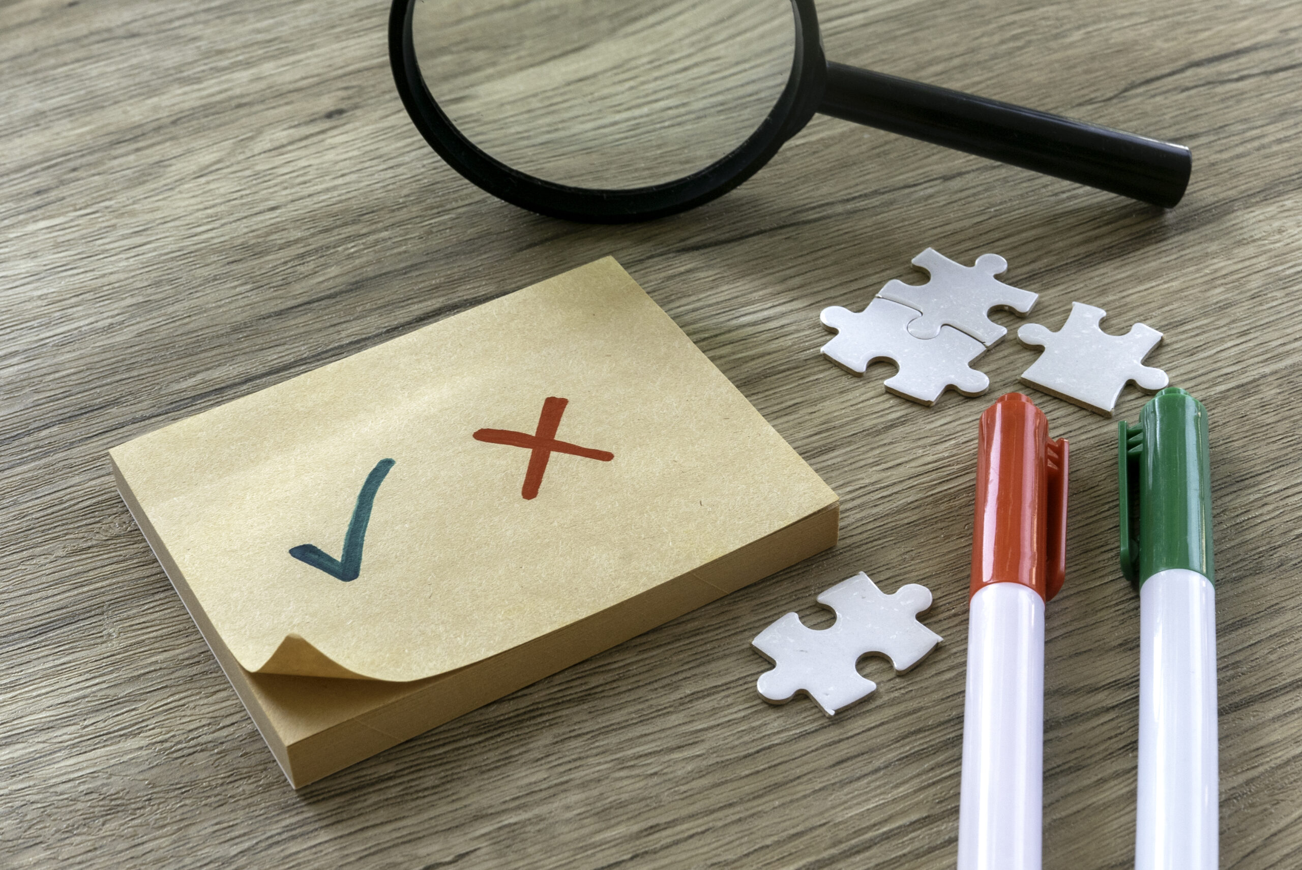 Image 4 Checklist with Green Check Mark and Red Cross on Sticky Note with Pens and Magnifying Glass