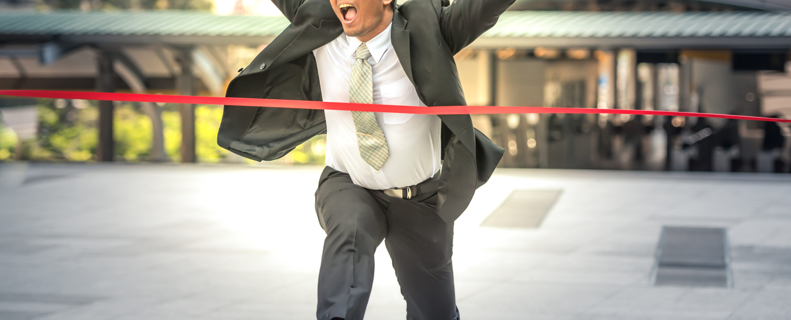 Young business man run past the finish line to success.