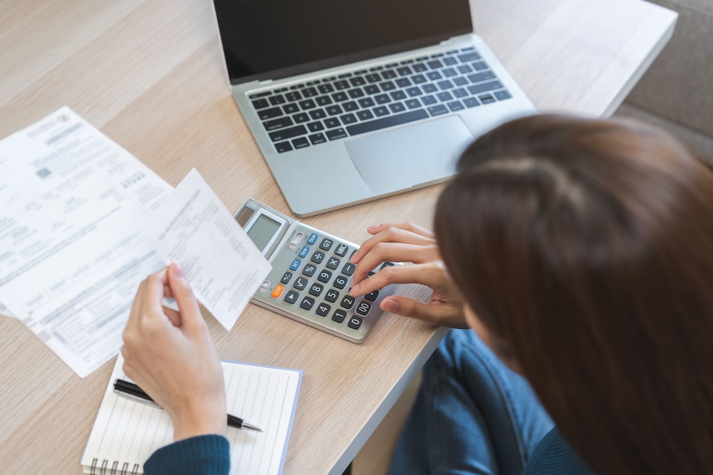 Image 1 Stressed asian young business woman, employee using calculator to calculate expenses of monthly, hand holding bills and receipt for to payment on table at home. Financial, finance of banking concept.