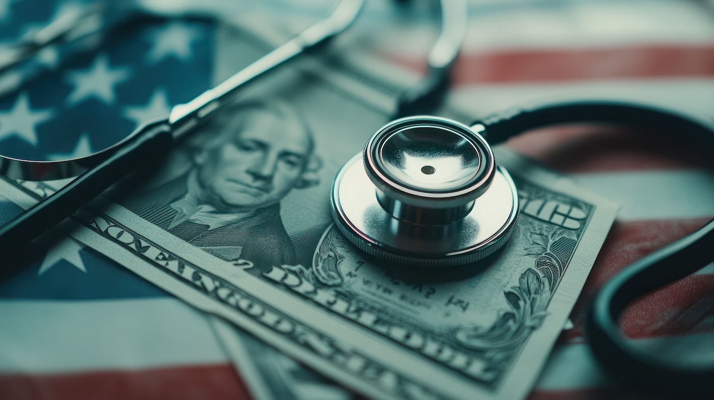 Capa Close-up image shows a stethoscope and magnifying glass lying on a twenty dollar bill, with an American flag in the background. The color palette is muted, with cool tones dominating. This image could be used for illustrations related to healthcare costs, medical insurance, or financial aspects of healthcare.