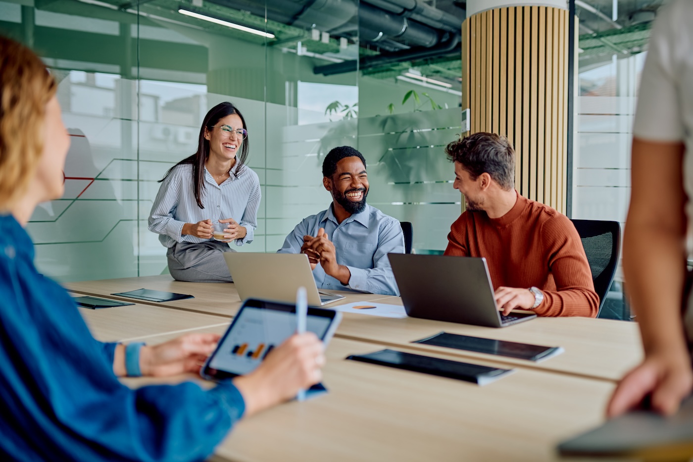 Diverse business team collaborating and laughing during office meeting Diverse business team collaborating and laughing during office meeting