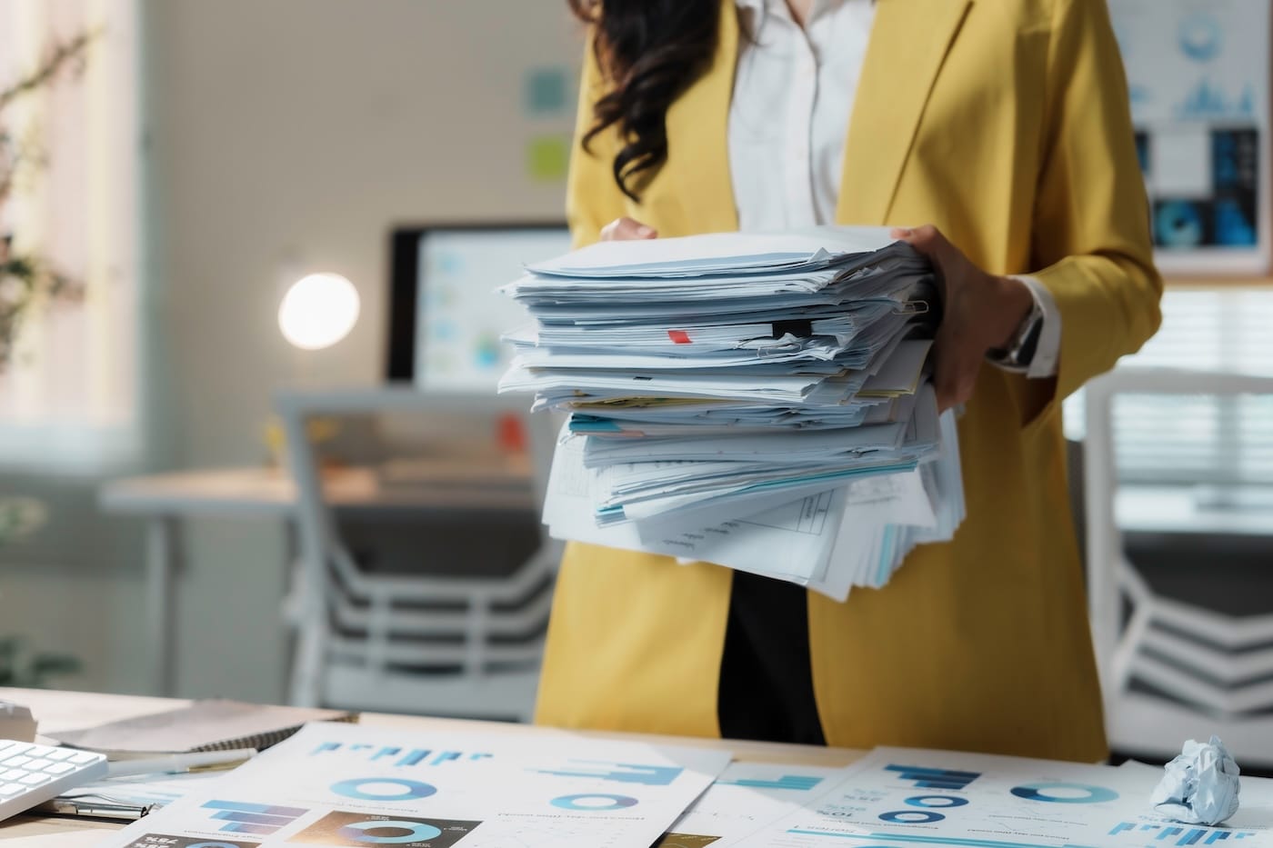 HR professional carrying a tall stack of enrollment paperwork HR professional carrying a tall stack of enrollment paperwork